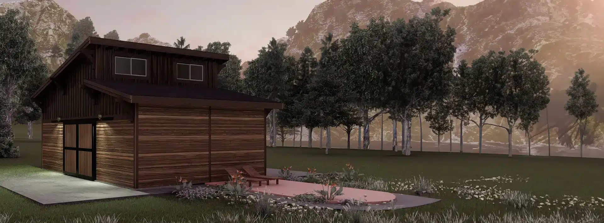 A small modern wooden cabin with large windows sits near a circular patio with chairs, surrounded by flowers and trees, mountains in background.