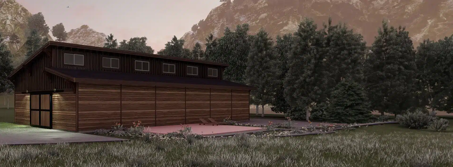 A modern wooden barn with large windows stands by a small empty pool, flower beds, pine trees, and mountains at sunset.