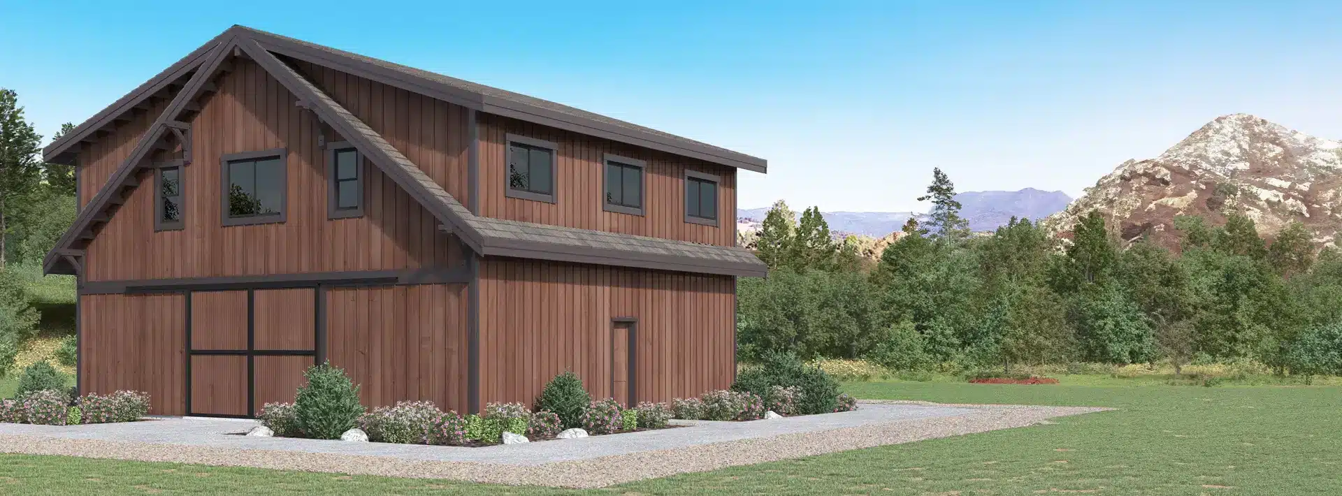 A modern two-story wooden barn with large windows sits on landscaped grounds with grass, shrubs, and trees. Mountains and a clear blue sky are visible in the background.
