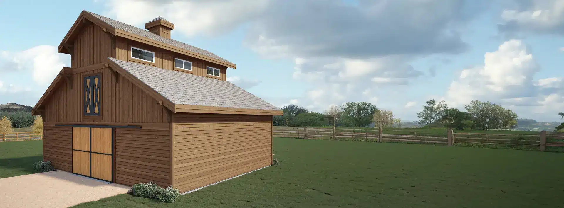 A large wooden barn with a pitched roof stands on a grassy field bordered by a wooden fence. Trees and clouds are in the background.