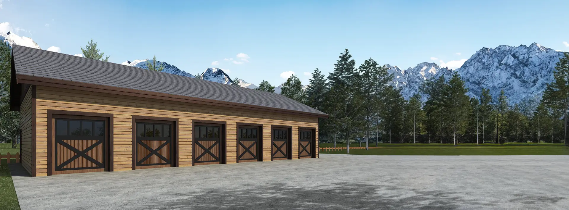 A large wooden building with five stable doors stands on a paved area, surrounded by trees and grass, with snow-capped mountains and a blue sky in the background.