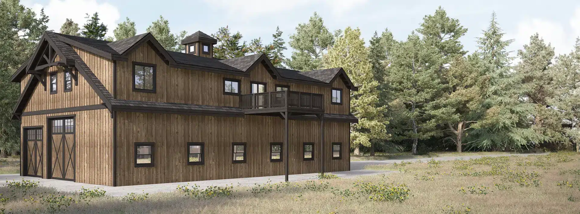 A two-story rustic wooden barn with large doors and multiple windows sits in a grassy field surrounded by tall trees.