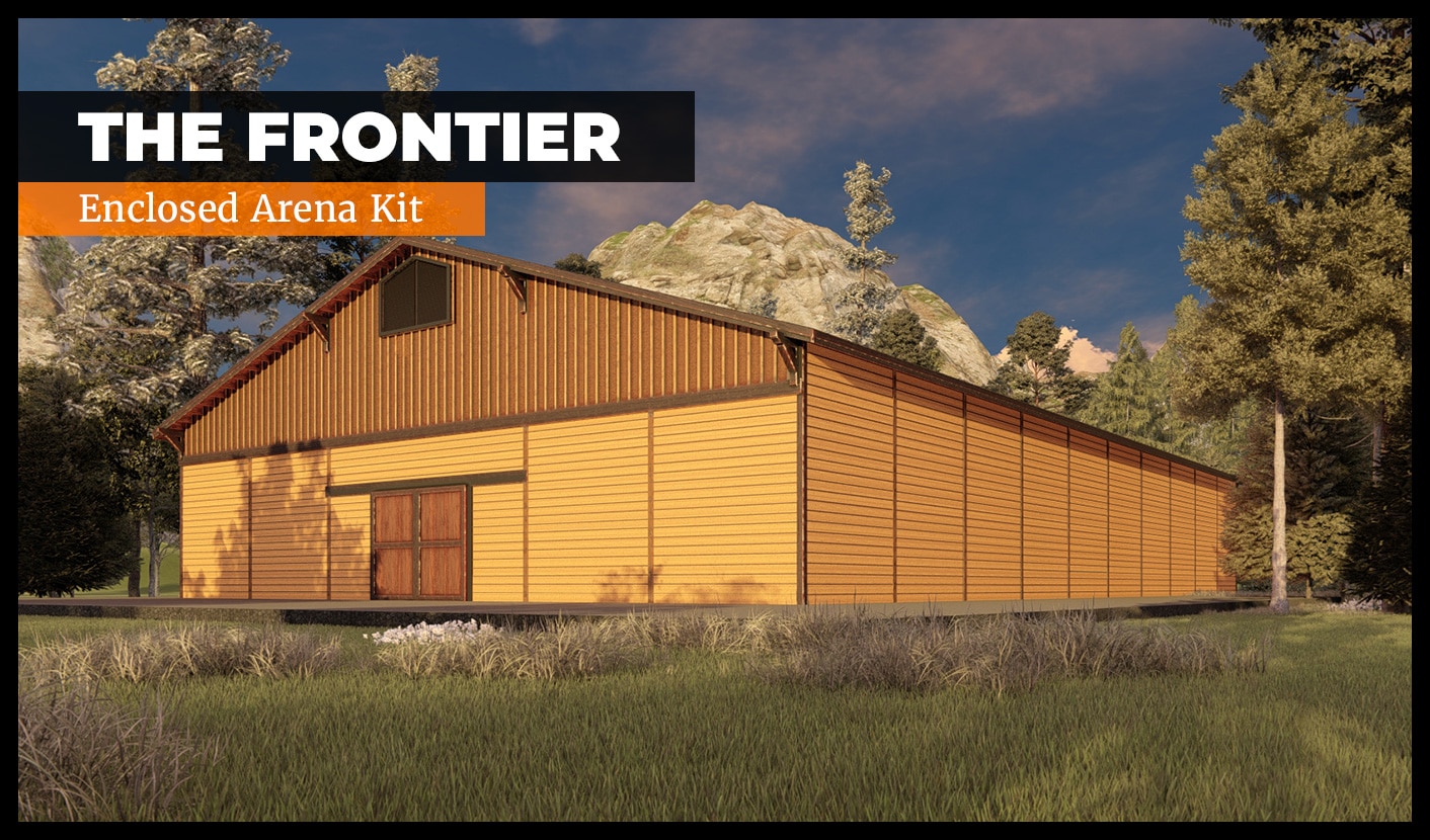 A large wooden building labeled "The Frontier Enclosed Arena Kit" is set against a backdrop of trees and rocky hills under a blue sky. The building features a pitched roof and double doors.