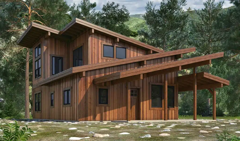 A modern two-story wooden cabin with large windows and slanted roofs among tall pine trees, greenery, rocks, and natural landscaping.