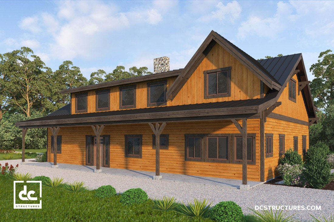 A two-story wooden house with large windows, a dark metal roof, and a covered porch. Surrounded by trees and greenery under a clear blue sky. A logo and URL appear in the lower corners.