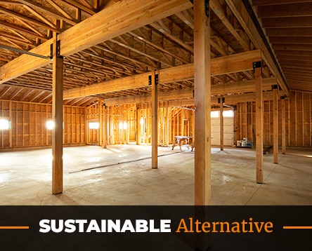 Interior view of a wooden structure with exposed beams and a concrete floor, highlighting sustainable architecture. Reminiscent of barn home kits, the design seamlessly merges rustic charm with modern efficiency. The words "Sustainable Alternative" are displayed at the bottom in bold lettering.