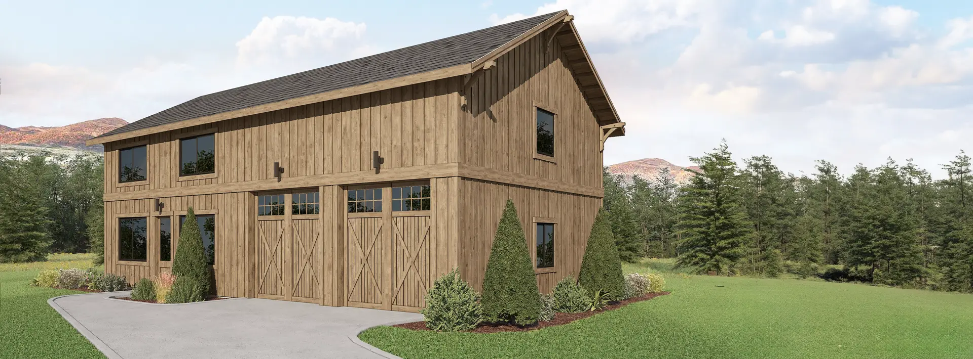A large two-story wooden barn with multiple windows and three doors, surrounded by grass, shrubs, trees, mountains and blue sky.