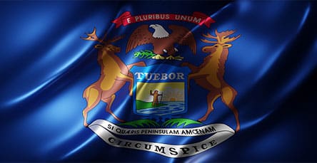 The flag of the state of Michigan features the state coat of arms on a dark blue field. The coat of arms includes an eagle, a shield with a man, an elk and a moose, and banners with the mottos "E Pluribus Unum," "Tuebor," and "Si Quaeris Peninsulam Amoenam Circumspice." Interestingly, historical designs resembling apartment