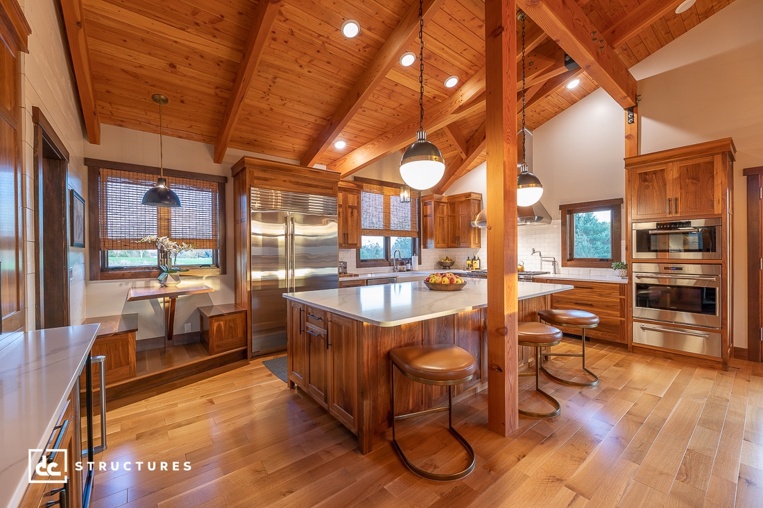 a modern kitchen designed with heavy timber posts and beams