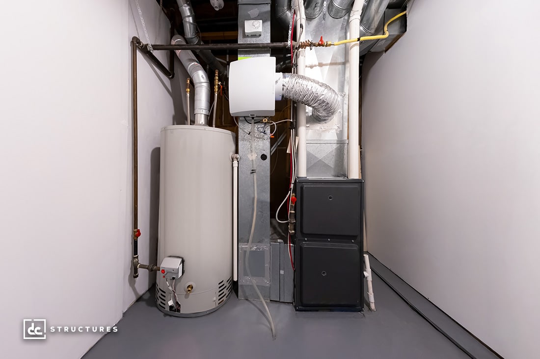 A basement with a water heater, HVAC system, and air ducts. The equipment is neatly installed against white walls, and pipes are visible, indicating a utility or maintenance area.