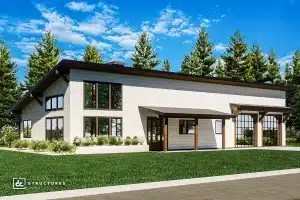 A modern single-story building with white siding, large windows, sloped roof, and wooden accents sits on a green lawn with pine trees.