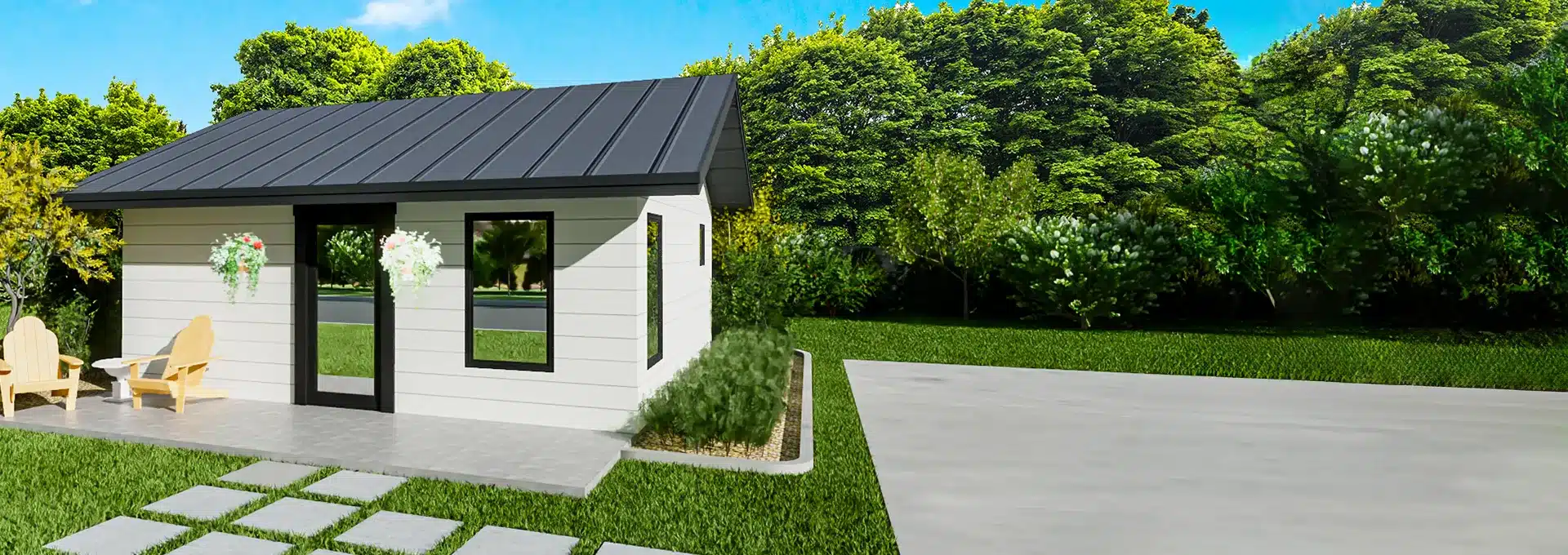 A small modern white house with black roof, large windows, and potted flowers sits by a patio amid green grass and dense trees.