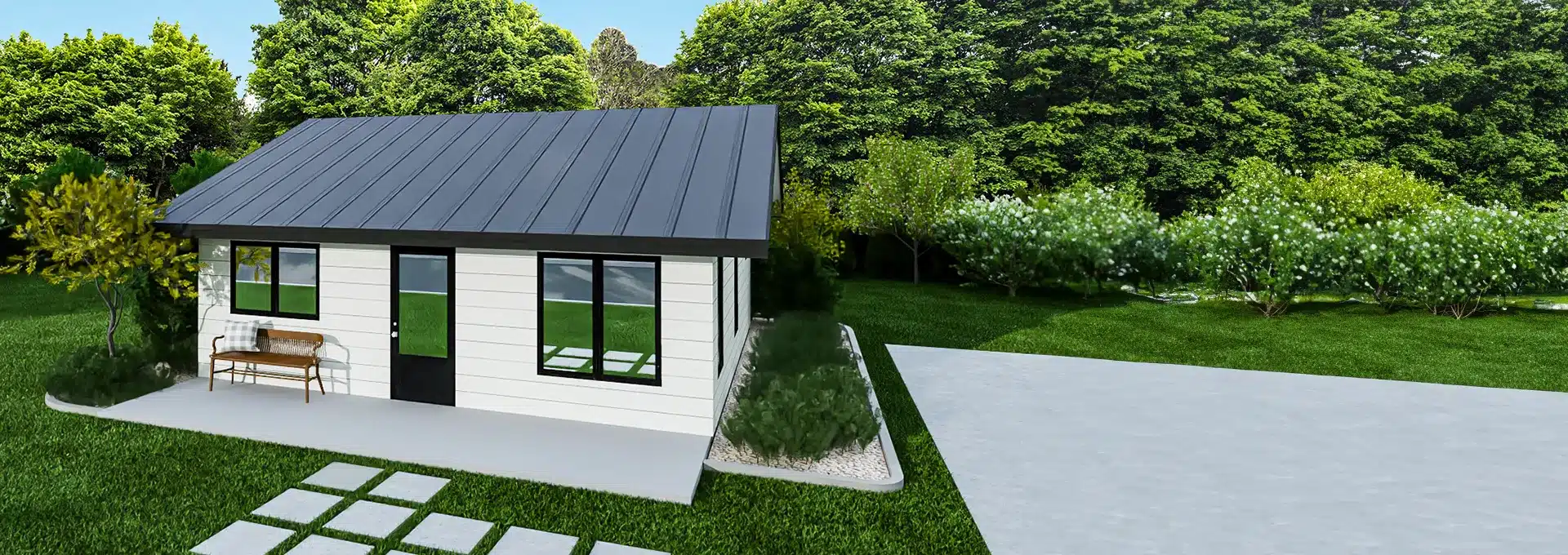 A small white house with a dark metal roof sits in a green yard with trees and bushes. A bench is by the door, with a paved path.